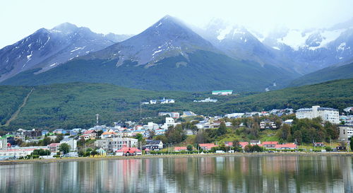 Scenic view of buildings by mountains against sky