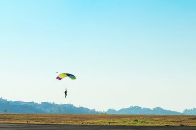 People flying over grassy field