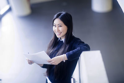 Young asia woman with paper in an office standing with paper