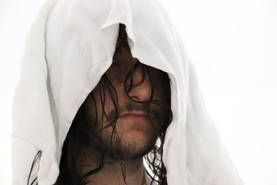 Close-up of man with white textile against clear sky