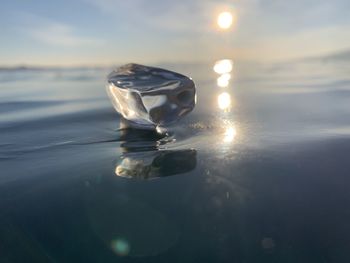 Close-up of water drop on sea against sky