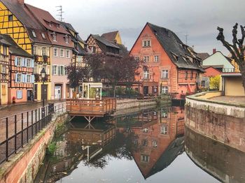 Canal amidst buildings in town against sky