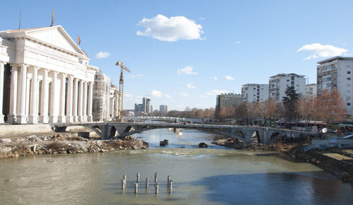 View of buildings in city against cloudy sky