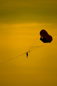 Low angle view of kite flying against sky during sunset