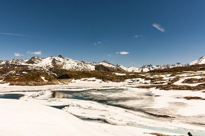 Scenic view of frozen mountains against sky