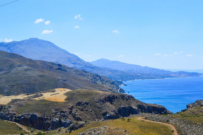 Scenic view of sea and mountains against sky