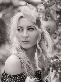 Thoughtful beautiful young woman looking away while standing in park