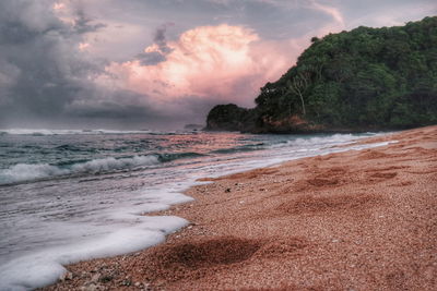 Scenic view of beach against sky during sunset