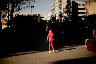 Rear view of woman walking on street at night