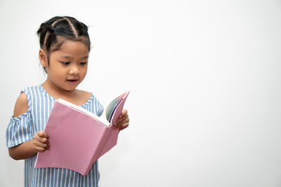 Girl holding book against white background