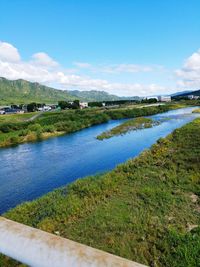 Scenic view of river against cloudy sky