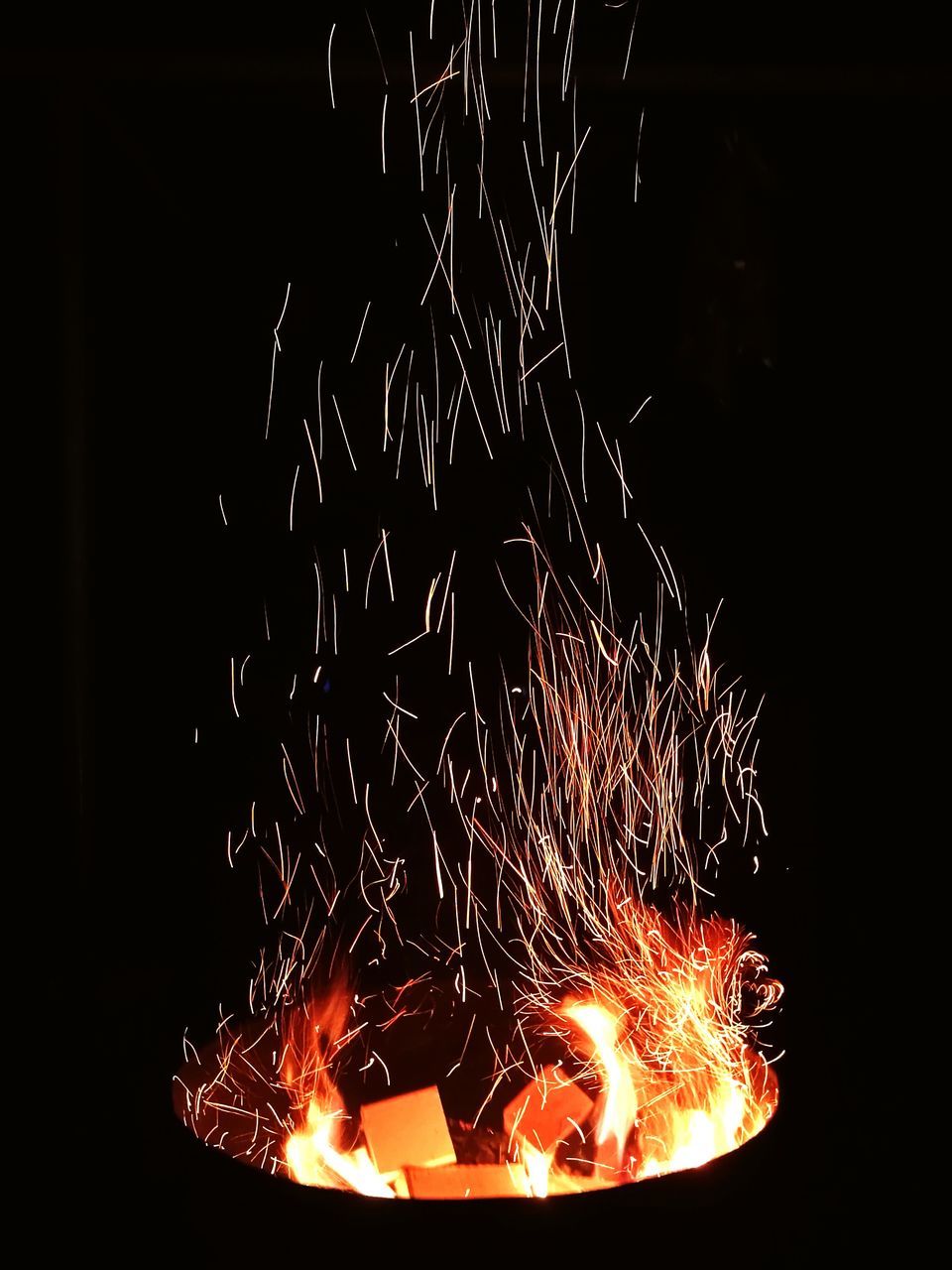 night, illuminated, long exposure, fire - natural phenomenon, glowing, firework display, celebration, motion, firework - man made object, sparks, exploding, burning, arts culture and entertainment, event, blurred motion, flame, firework, heat - temperature, low angle view, dark