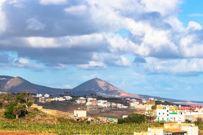 Houses by buildings against sky in city