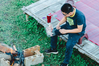 High angle view of senior man holding umbrella in yard