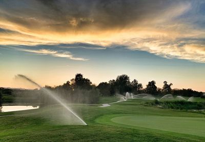 Scenic view of golf course against sky