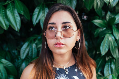 Portrait of a beautiful teenager looking through her sunglasses