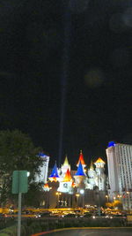 Illuminated buildings against sky at night