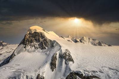 Scenic view of snowcapped mountains against sky during sunset