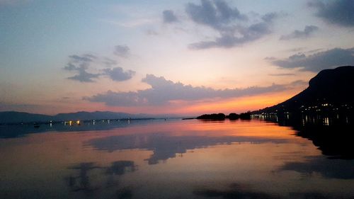 Scenic view of lake against sky at sunset