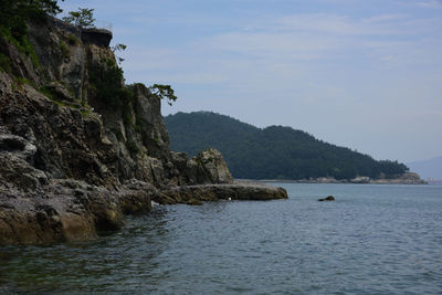 Rock formations by sea against sky