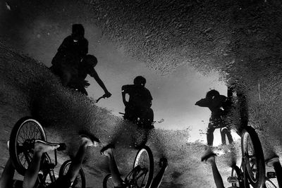 Reflection of friends on puddle during monsoon