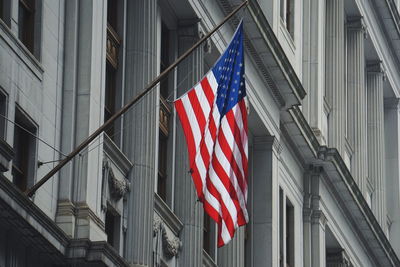 American flag hanging on building in city