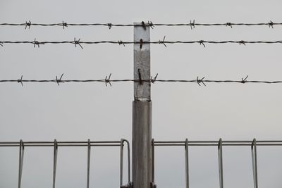 Low angle view of barbed wire against clear sky