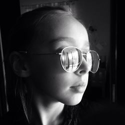 Close-up portrait of a girl wearing sunglasses at home