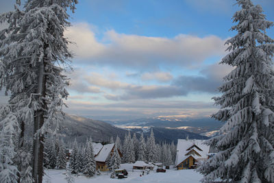 Snow covered landscape against sky during winter
