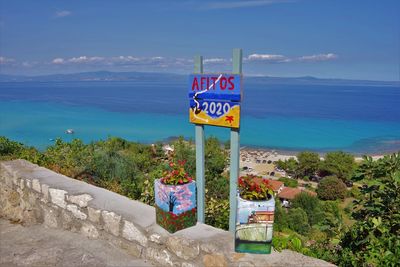 Information sign on beach against sky