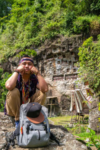 Portrait of young man sitting on rock