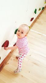 Cute baby girl on hardwood floor at home