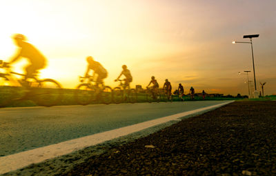 Blur photo sports man ride bicycles with speed motion on the road in the evening with sunset sky. 