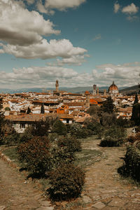 Buildings in city against cloudy sky