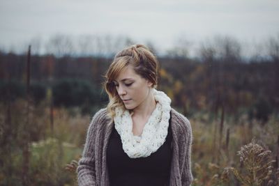 Young woman looking away on field