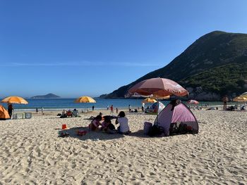 People on beach against sky