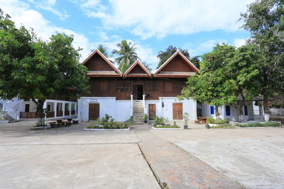 Houses by trees and buildings against sky