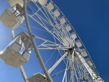 Low angle view of ferris wheel against clear blue sky