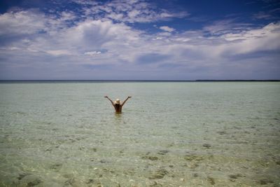 Man in sea against sky