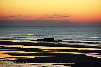 Scenic view of beach against sky during sunset