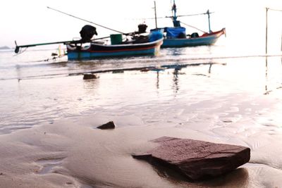 Boat moored on beach against sky