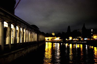 Illuminated bridge over river at night