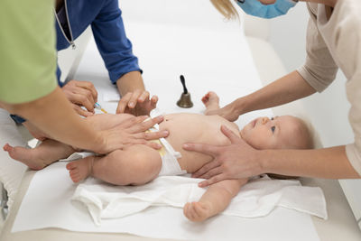 Midsection of doctor examining patient on bed