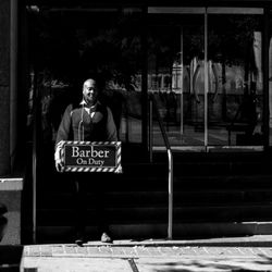 Portrait of man standing by window at store