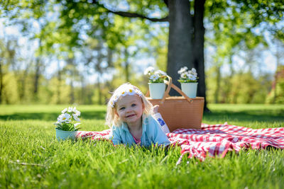 Portrait of girl sitting in basket on grass