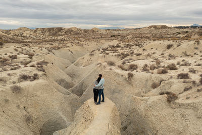 Rear view of man walking on sand at desert