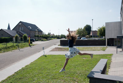 Teenage girl doing acrobatic exercises on a green lawn, sport, generation z,