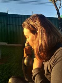 Midsection of woman holding chocolate while sitting outdoors