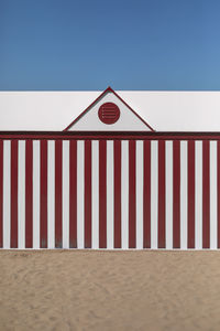 Lifeguard hut on beach against clear blue sky