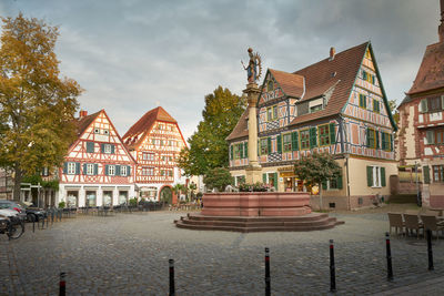 Houses by street and buildings against sky